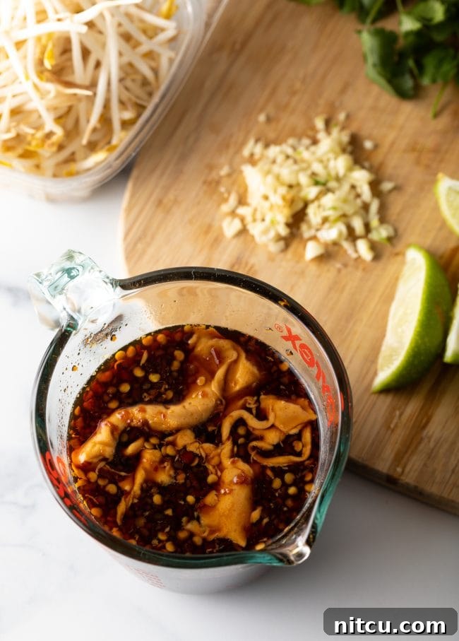 Classic Chicken Pad Thai Stir-fry 5 Top-down view of sauce ingredients meticulously blended in a glass measuring cup, ready for the Pad Thai stir-fry.