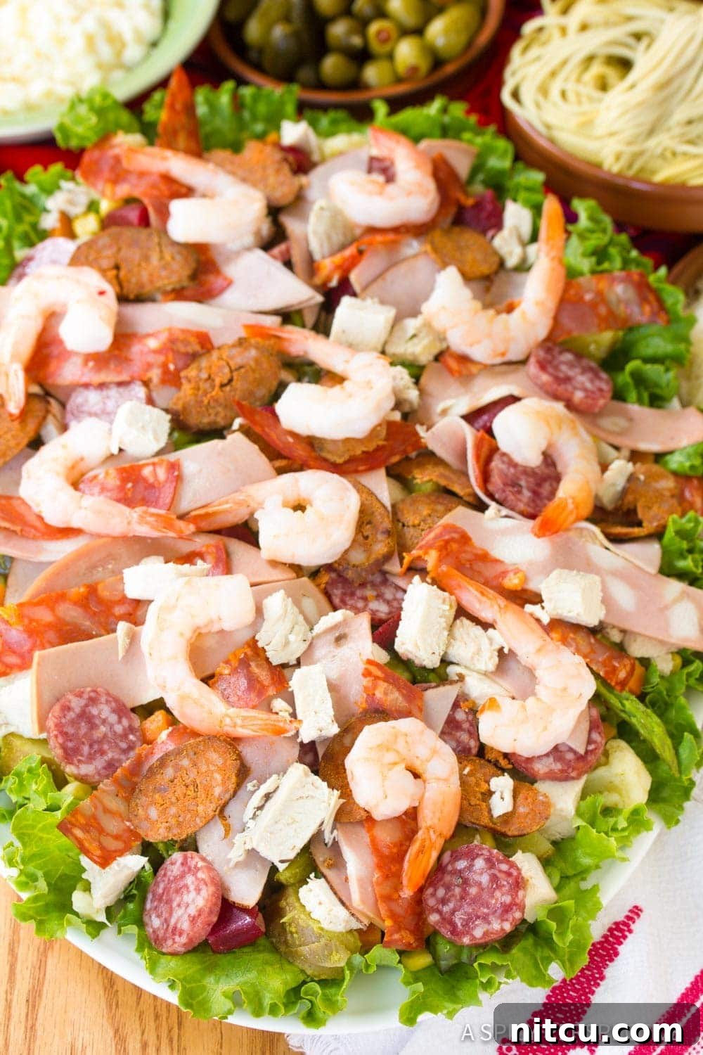 Layered Legacy: Guatemalan Fiambre 6 A plate of assorted cured meats and shrimp arranged on a bed of fresh lettuce, ready for the Fiambre salad.