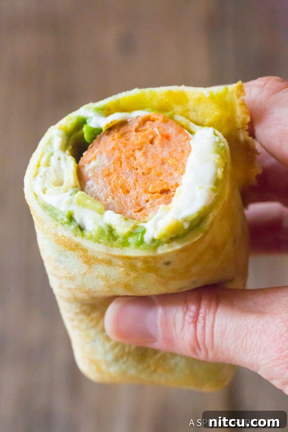 Quick Keto Egg Wraps 3 Hand holding an breakfast egg wrap recipe.