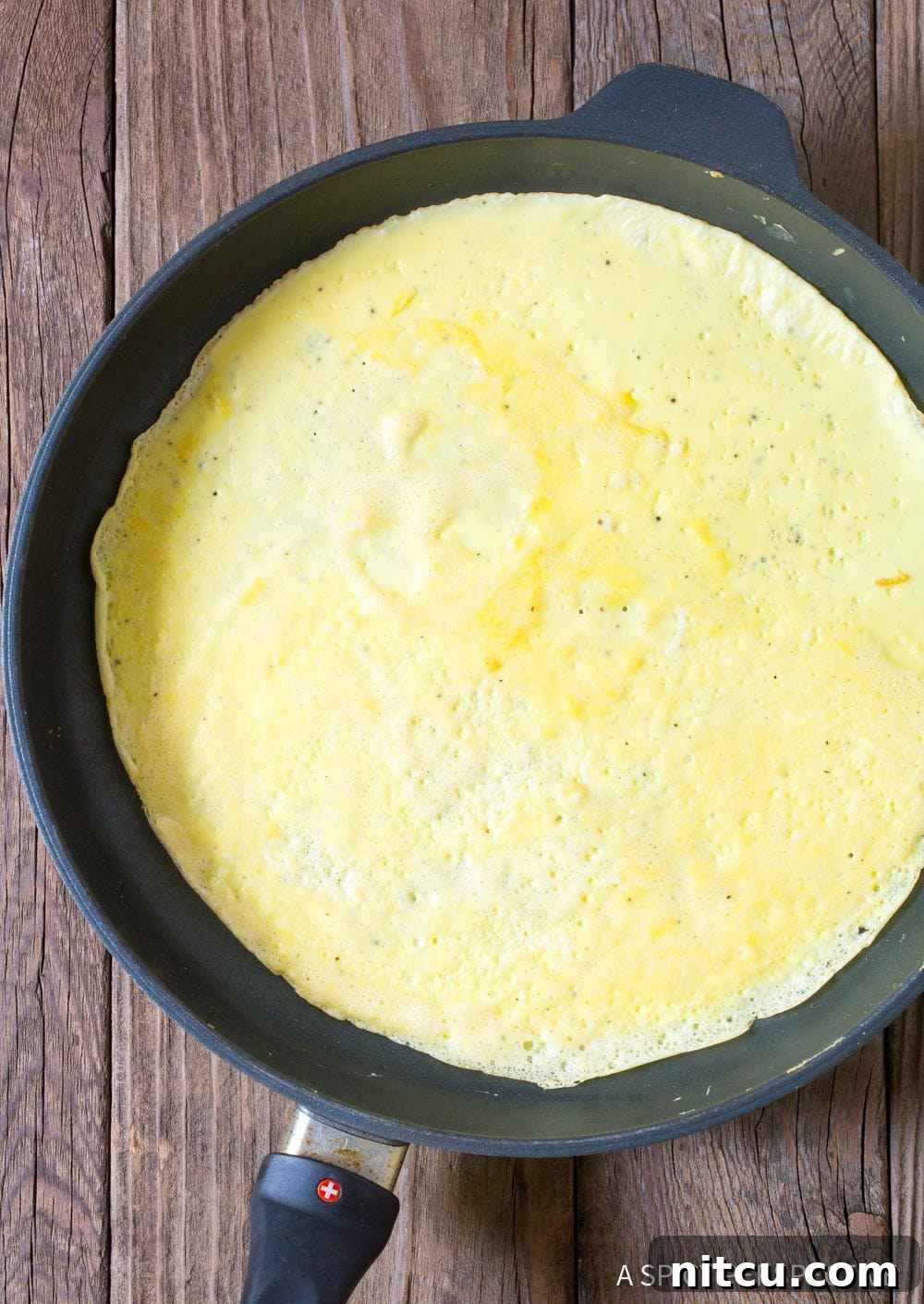 Quick Keto Egg Wraps 5 Making an egg tortilla in a skillet.