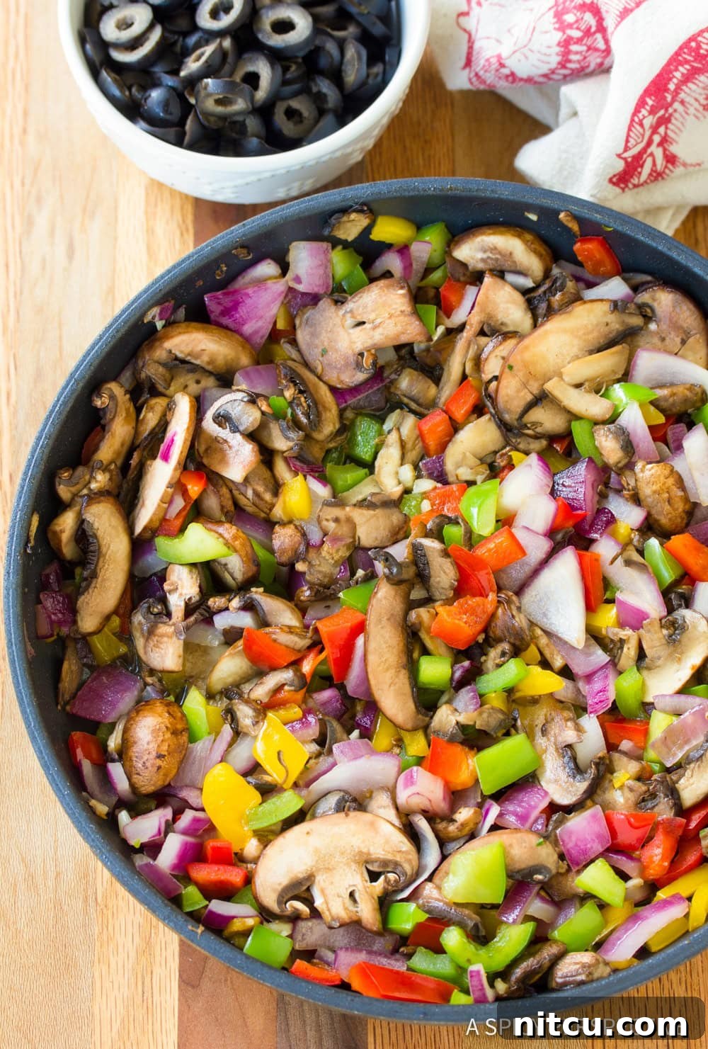 Fully Loaded Pizza Lasagna 4 A close-up shot of colorful bell peppers, onions, and mushrooms sautéing lightly in a skillet, filling the pan with vibrant ingredients and a tantalizing aroma.
