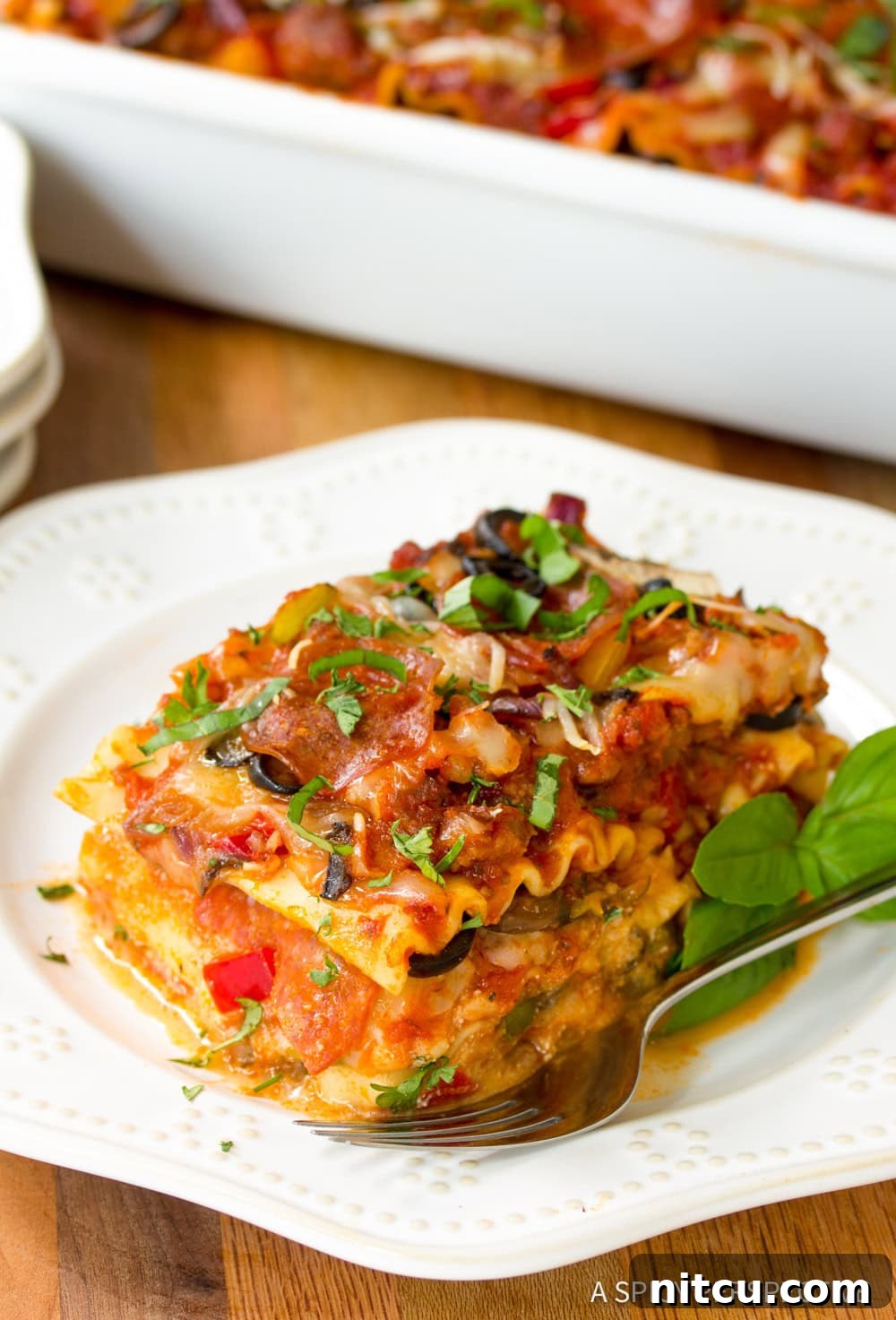 Fully Loaded Pizza Lasagna 7 A perfect, golden-brown slice of Supreme Pizza Lasagna elegantly plated, showcasing its distinct layers and tempting toppings.