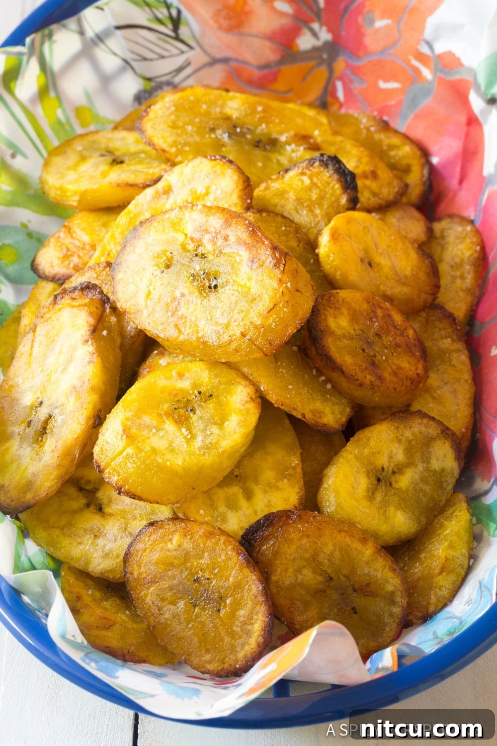 Golden Baked Plantains 8 A woven basket filled with freshly baked, golden-brown crispy plantains, ready to be enjoyed as a snack or side.