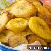 The Perfect Baked Plantains Recipe - a close-up of golden, tender slices.
