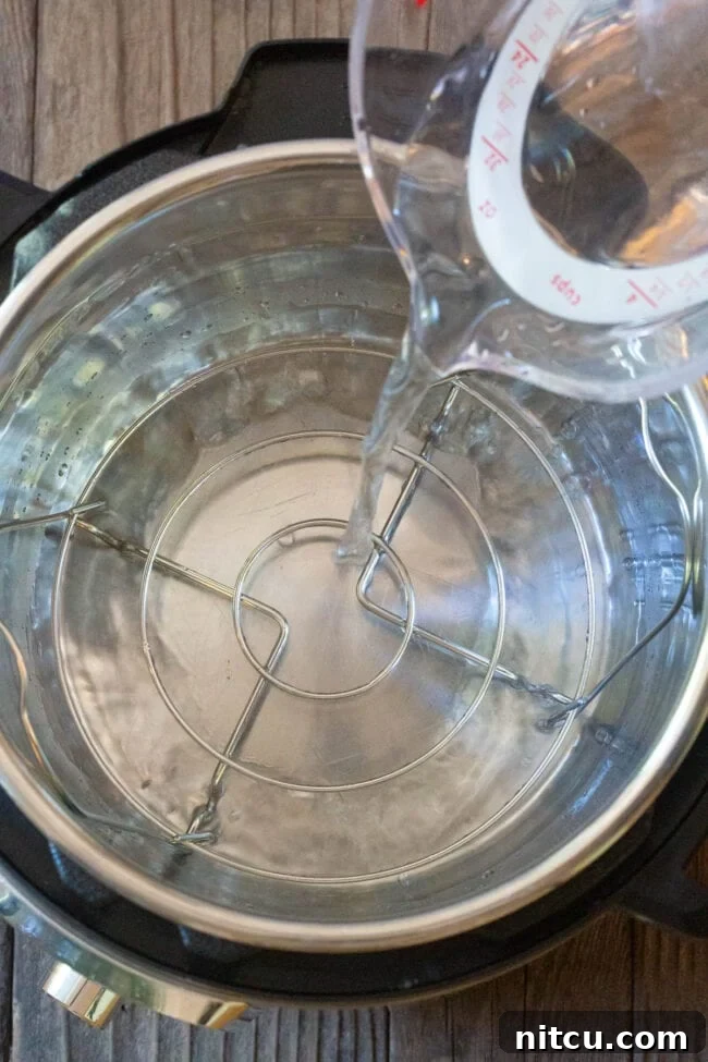 Simple Instant Pot Keto Crustless Quiche 4 Pouring water into the Instant Pot base, preparing for pressure cooking the quiche in a water bath.