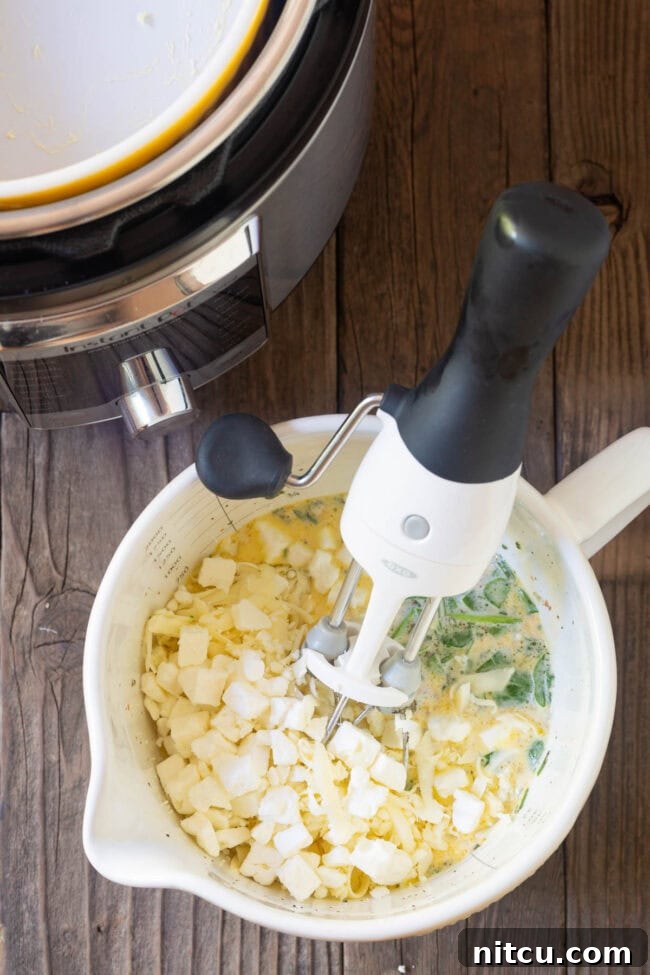 Simple Instant Pot Keto Crustless Quiche 5 Mixing bowl with quiche ingredients being whisked together by an electric mixer.