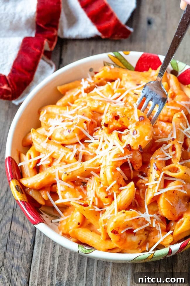 Velvety Instant Pot Vodka Shrimp Pasta 11 Bowl of penne alla vodka with shrimp with a fork taking a piece of shrimp. I