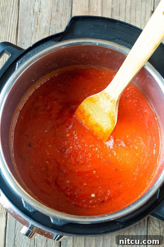 Velvety Instant Pot Vodka Shrimp Pasta 6 Tomato sauce cooking in an instant pot.