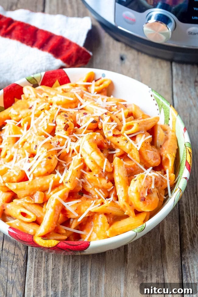 Velvety Instant Pot Vodka Shrimp Pasta 10 Bowl of shrimp alla vodka and pasta with parmesan on top.