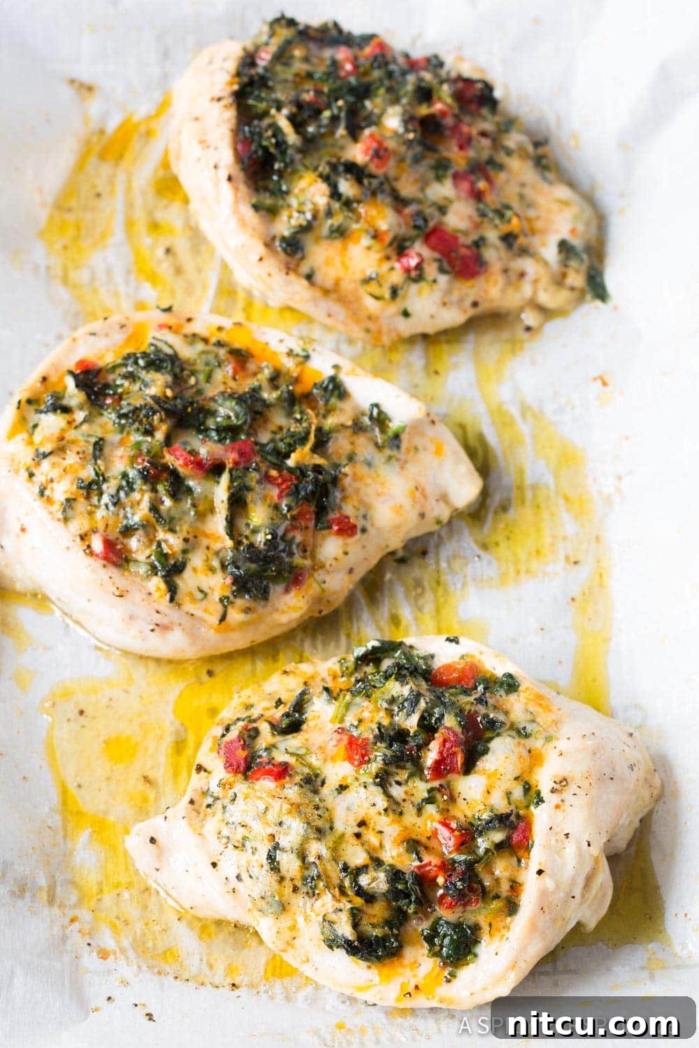Creamy Spinach-Stuffed Chicken 6 Stuffed chicken breasts on a baking sheet after being baked.