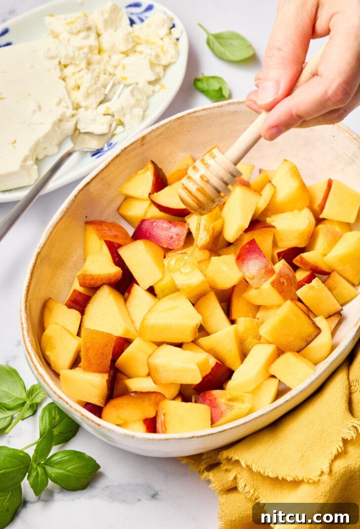 Freshly Chopped Peaches and Basil Close-up of chopped peach salad ingredients in a mixing bowl, showcasing vibrant peaches and fresh basil.