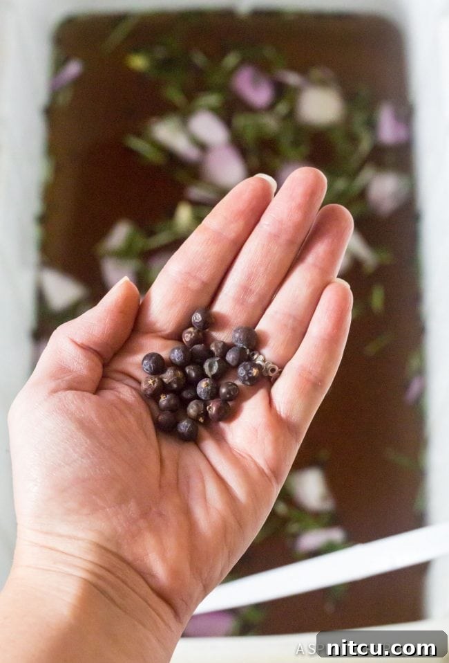 A hand adding peppercorns to a cooler filled with turkey brine, showing the brining process.