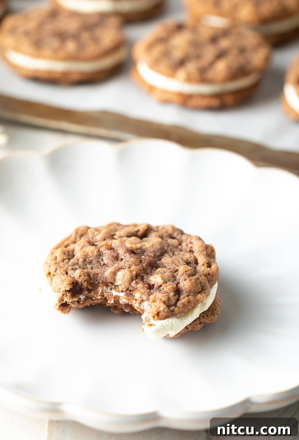 cream filling A delectable homemade oatmeal cream pie on a plate with a bite taken out, revealing its fluffy cream filling.