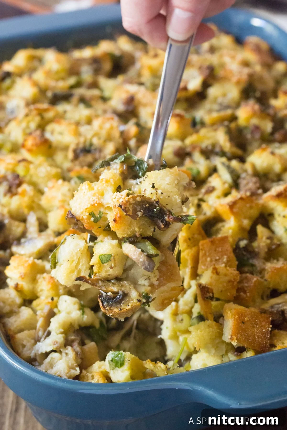 Savory Mushroom and Sausage Dressing 4 Best Sausage Mushroom Stuffing Recipe, spooned up with serving spoon.