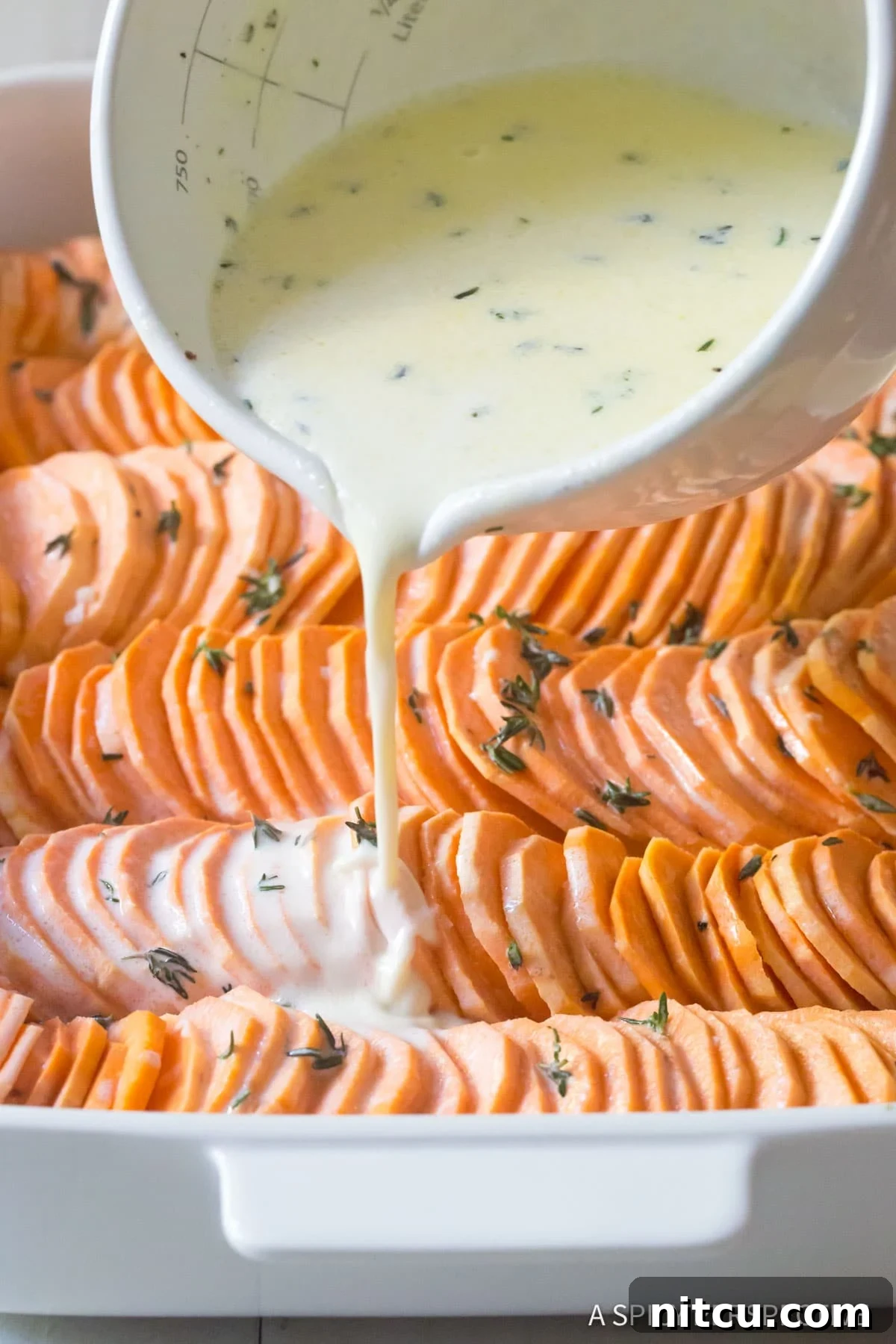 Scalloped Sweet Potato Au Gratin - pouring cream over sweet potatoes