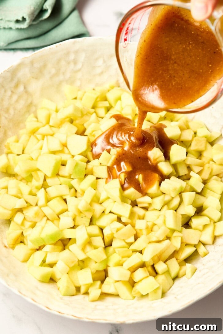 Individual Apple Tarts 5 Pouring rich brandy-infused syrup over freshly diced apples for the pie filling, creating an intoxicating aroma.