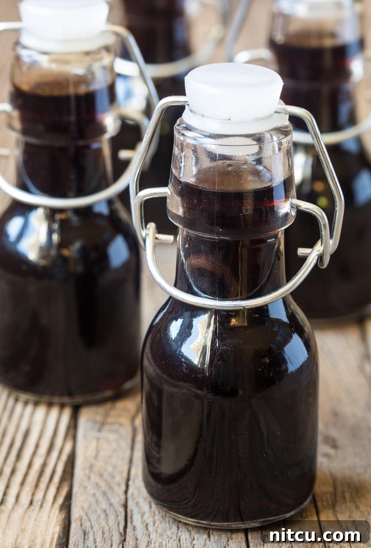 Artisan Bourbon Vanilla Extract 2 Little bottles of homemade vanilla on a wooden surface.