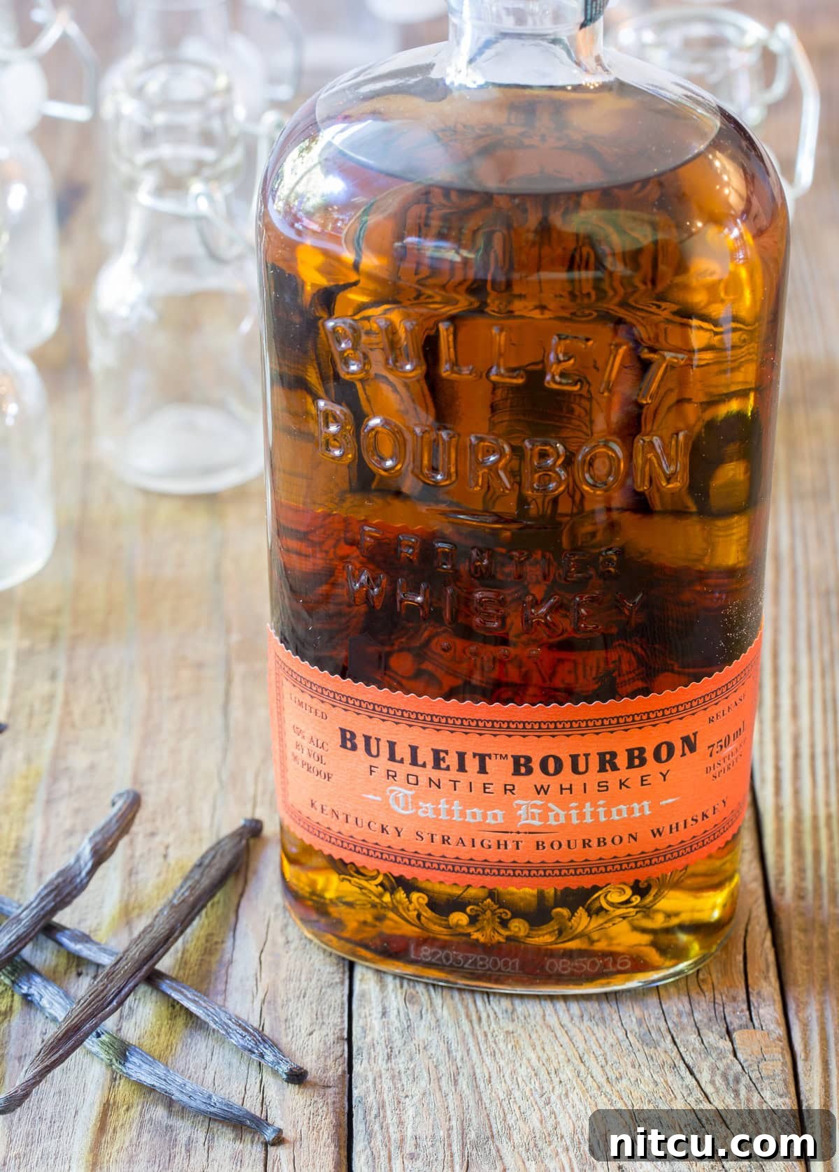 Artisan Bourbon Vanilla Extract 4 Bottle of bourbon with vanilla pods next to it.