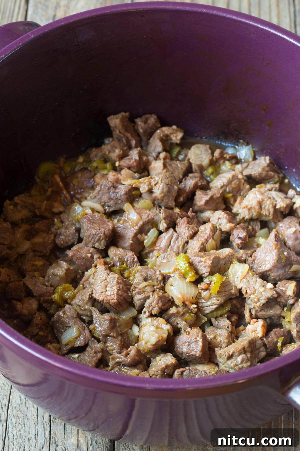 Hearty Beef Stew Perfection 3 Beef being perfectly seared and browned in a pot with vegetables.