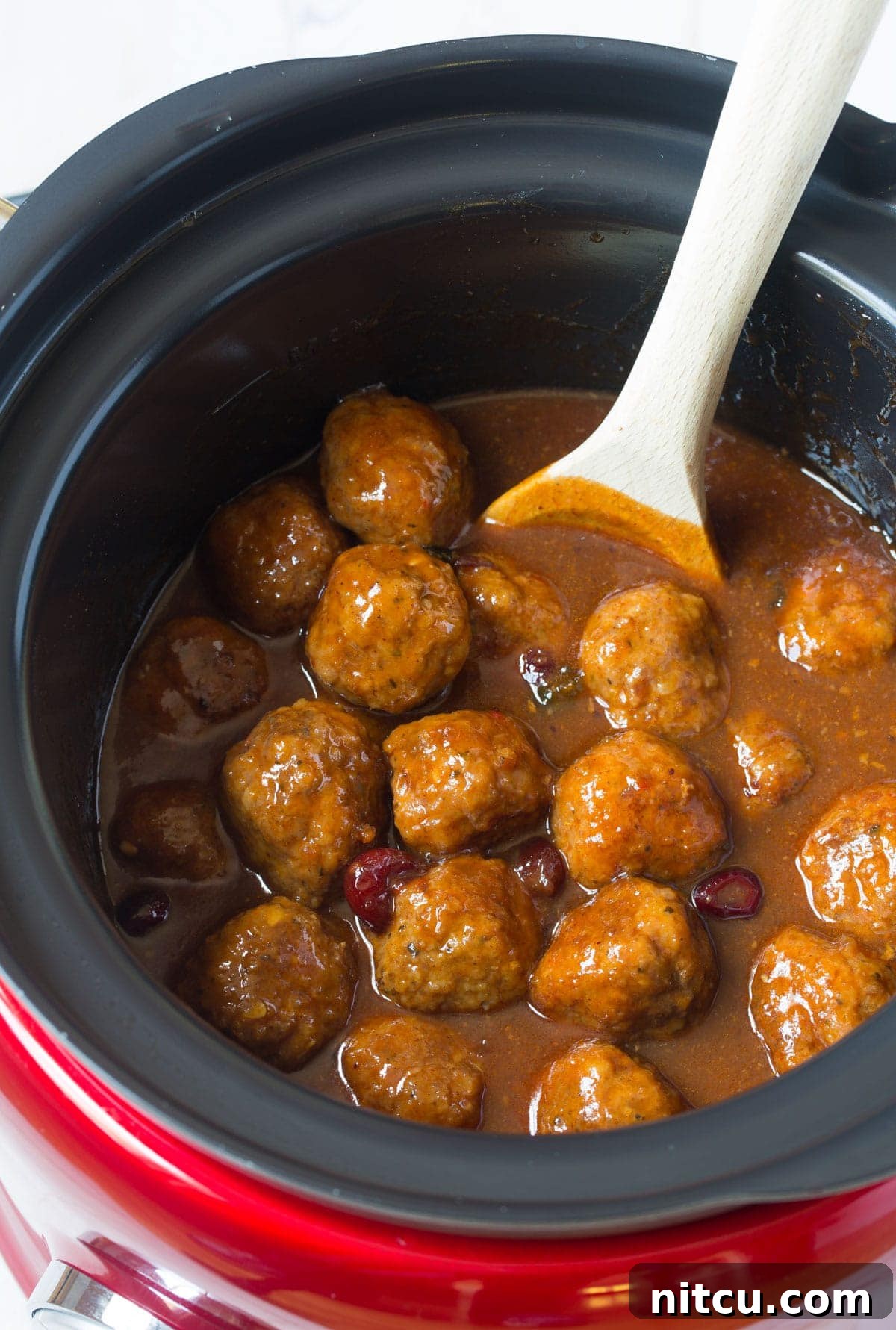 Crockpot Party Meatballs 2 Top view of delicious crock pot barbecue meatballs with a wooden spoon stirring them