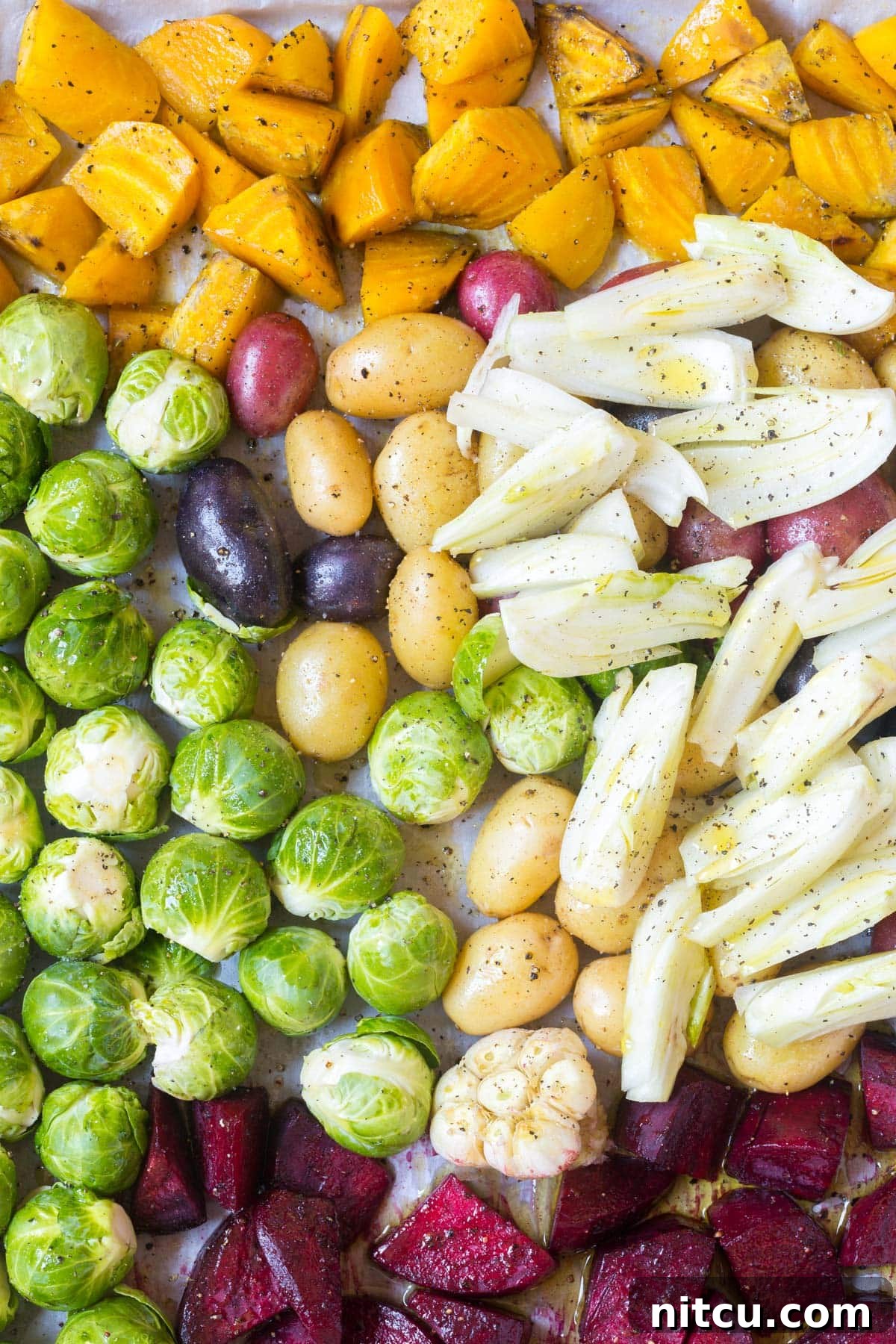 Raw vegetables including potatoes, beets, Brussels sprouts, and fennel on a baking tray, ready for roasting for the Florentine Steak platter