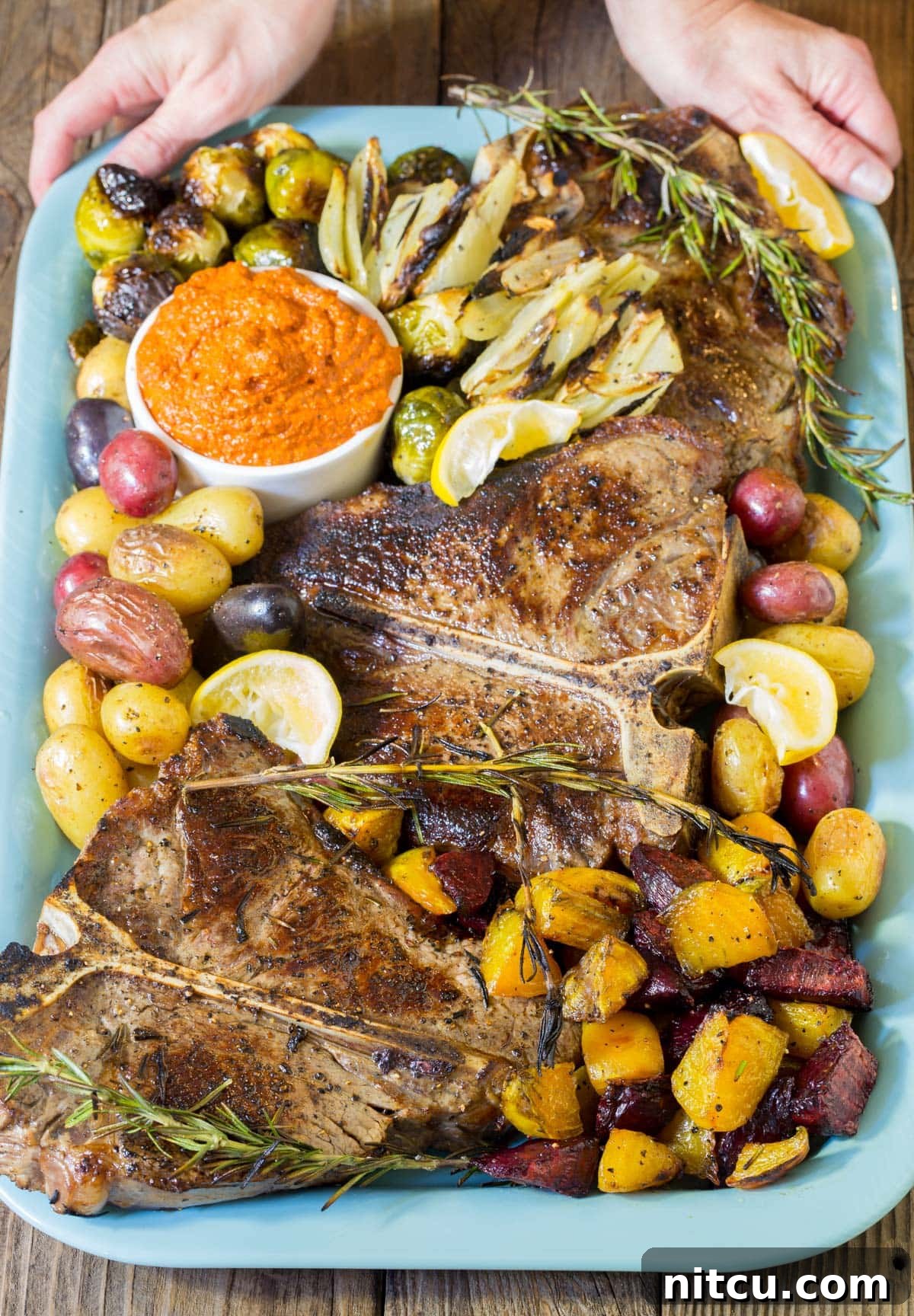 Tuscan Bistecca alla Fiorentina on a festive holiday platter, surrounded by roasted potatoes and other vegetables