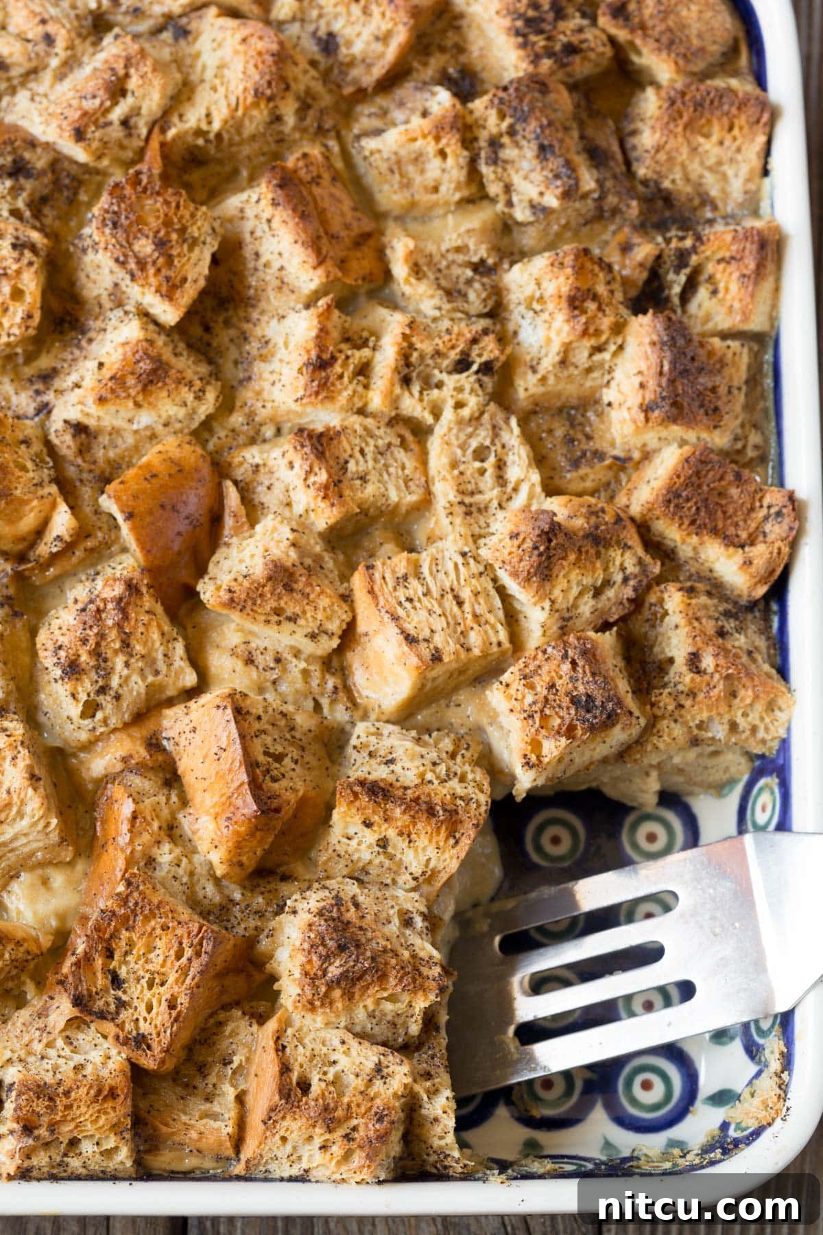 Espresso Bread Pudding Bliss 2 Vietnamese Coffee Bread Pudding in a baking dish with a spatula scooping it out.