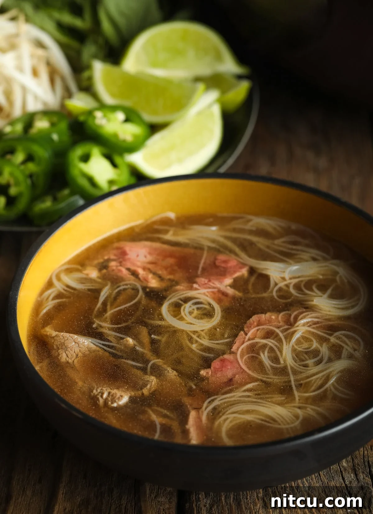 Wholesome Pho Creation 9 A steaming bowl of healthy paleo pho soup, featuring low-carb noodles and thinly sliced beef, with a rich broth.