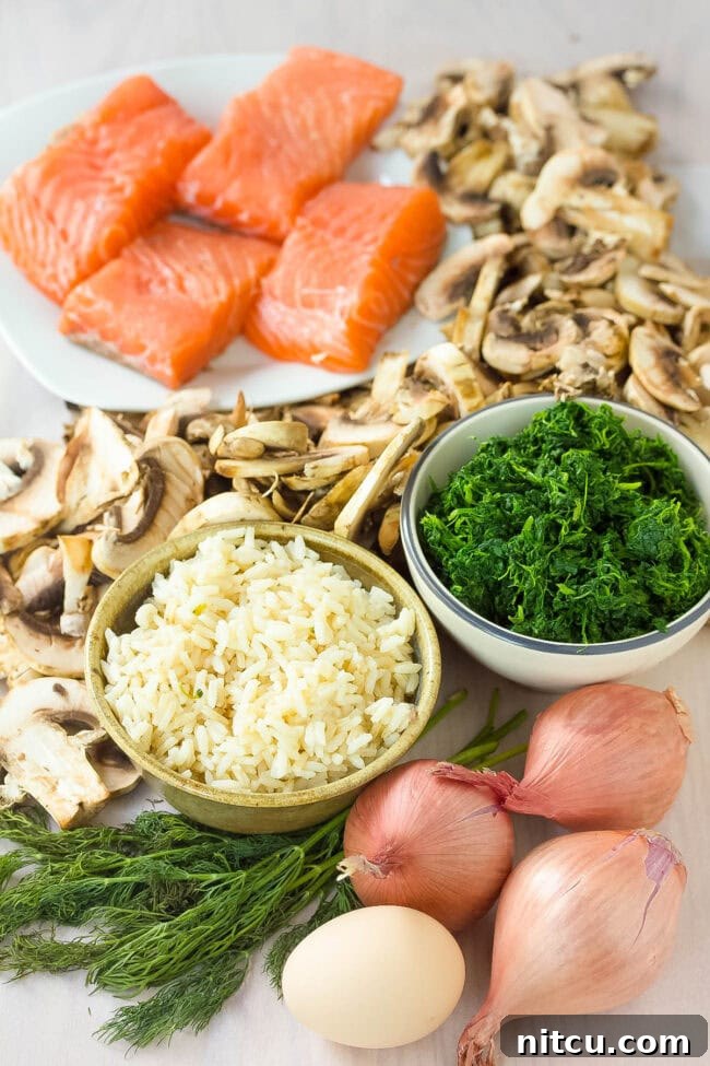 Regal Salmon Pie 4 A collection of fresh ingredients laid out for making Salmon Wellington, including salmon fillets, puff pastry, mushrooms, spinach, and dill.