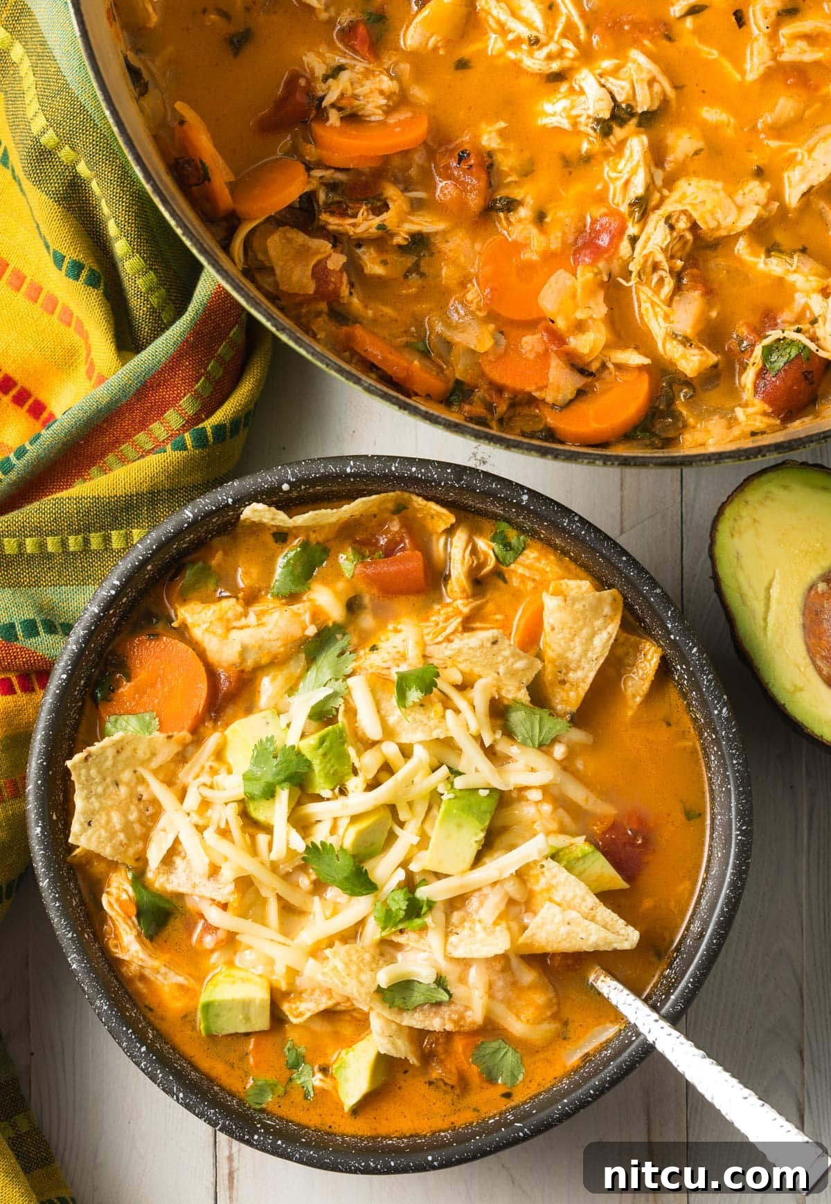 Top view of chicken tortilla soup recipe in the pot and a serving as well in a bowl ready to eat