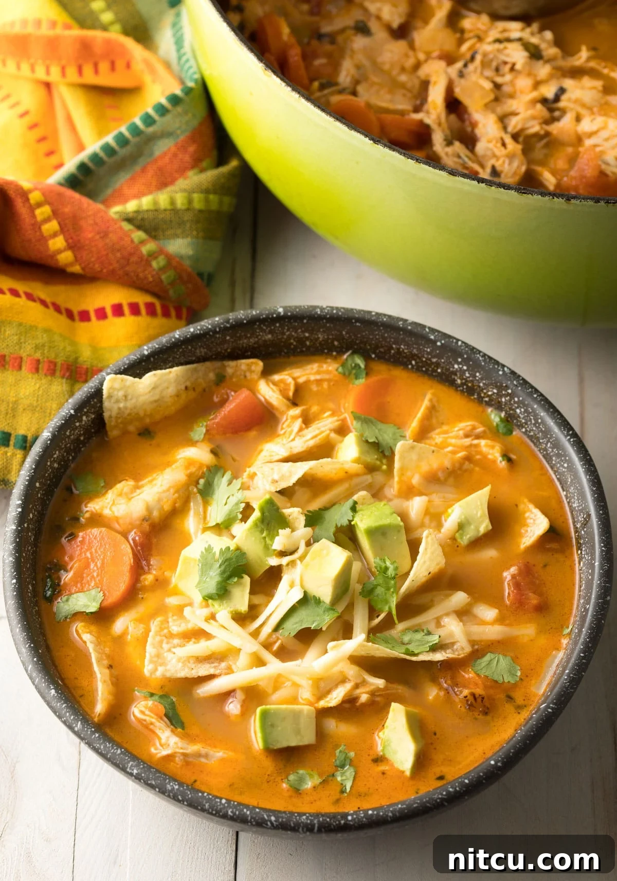 mexican soup recipe that is topped with avocado and cilantro