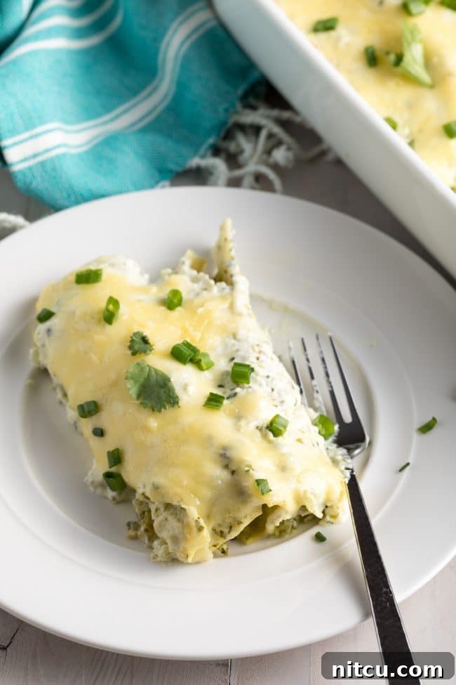 Creamy Swiss Enchiladas 14 The Perfect Enchiladas Suizas Recipe (Creamy Chicken Enchiladas) on a cutting board, garnished.