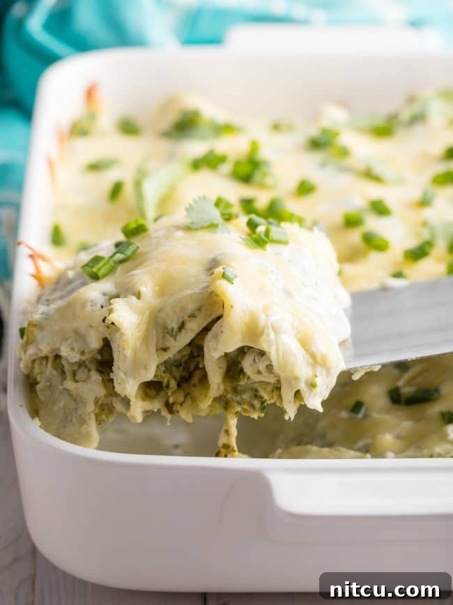 Creamy Swiss Enchiladas 3 Perfect Enchiladas Suizas lifted out of pan, showing the creamy filling.
