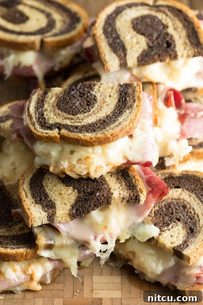 Golden Baked Reuben Sandwich 4 Baked Reuben sandwiches, beautifully stacked on a wooden background, highlighting their delicious layers.