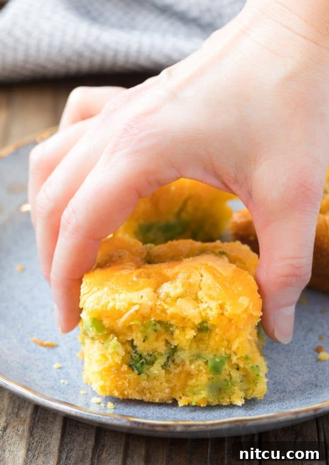 Garden Harvest Cornbread 6 Hands reaching for a piece of Jiffy Broccoli Cornbread from a pan