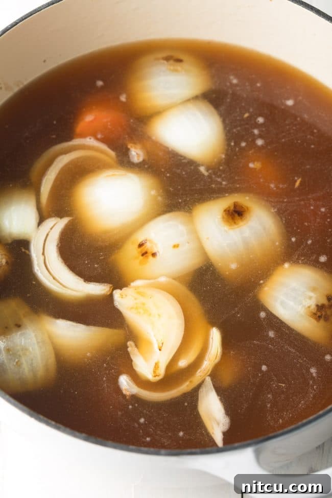 Elegant Dashi Broth 8 Soup simmering in a large pot with big pieces of veggies in it.
