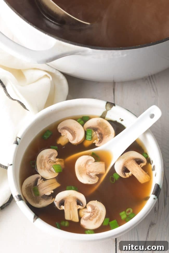 Elegant Dashi Broth 9 Best Japanese clear soup in a bowl with a white soup spoon.