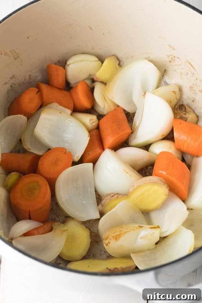 Elegant Dashi Broth 6 Carrots, onions, garlic and ginger being sautéed in a large stock pot.