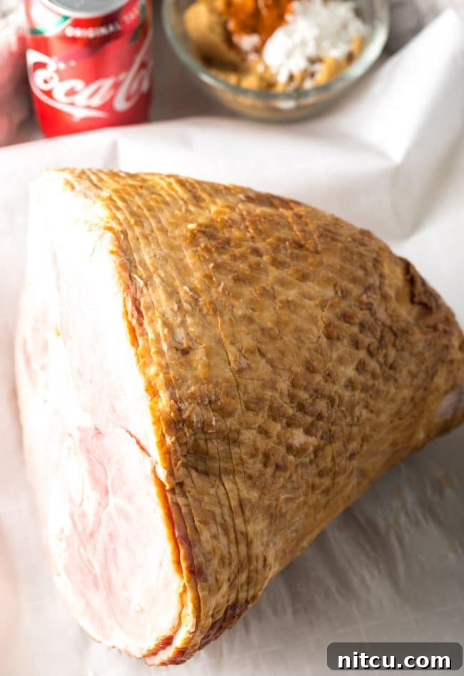 Coca-Cola Uncut 4 A spiral-cut ham resting on a baking sheet, displaying its natural grooves before the glaze is applied.