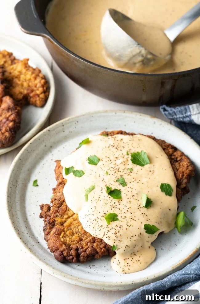 Effortless Chicken Fried Steak 2 Best Chicken Fried Steak Recipe: A perfectly golden-brown, crispy chicken fried steak topped with a generous dollop of creamy white gravy, ready to be served as a classic Southern comfort meal.