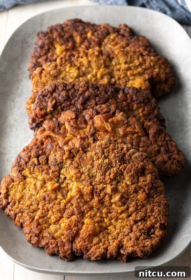 Effortless Chicken Fried Steak 3 Country Fried Steak: A close-up shot of a golden-brown, crispy country fried steak, showcasing its textured breading and inviting appearance before gravy is added.