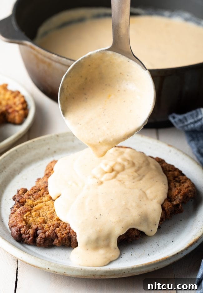 Effortless Chicken Fried Steak 4 Fried Steak Recipe: A plate of freshly fried steaks, golden and crispy, highlighting the inviting texture of the breading before being drenched in gravy.
