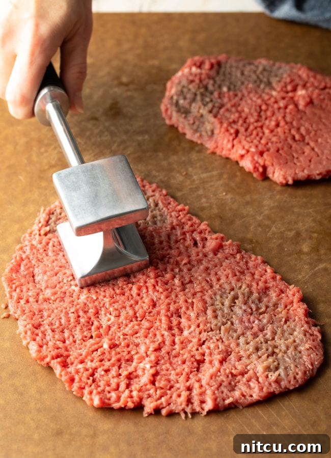 Effortless Chicken Fried Steak 5 Cube Steak: A piece of tenderized cube steak, ready for breading and frying, showing its characteristic textured surface.