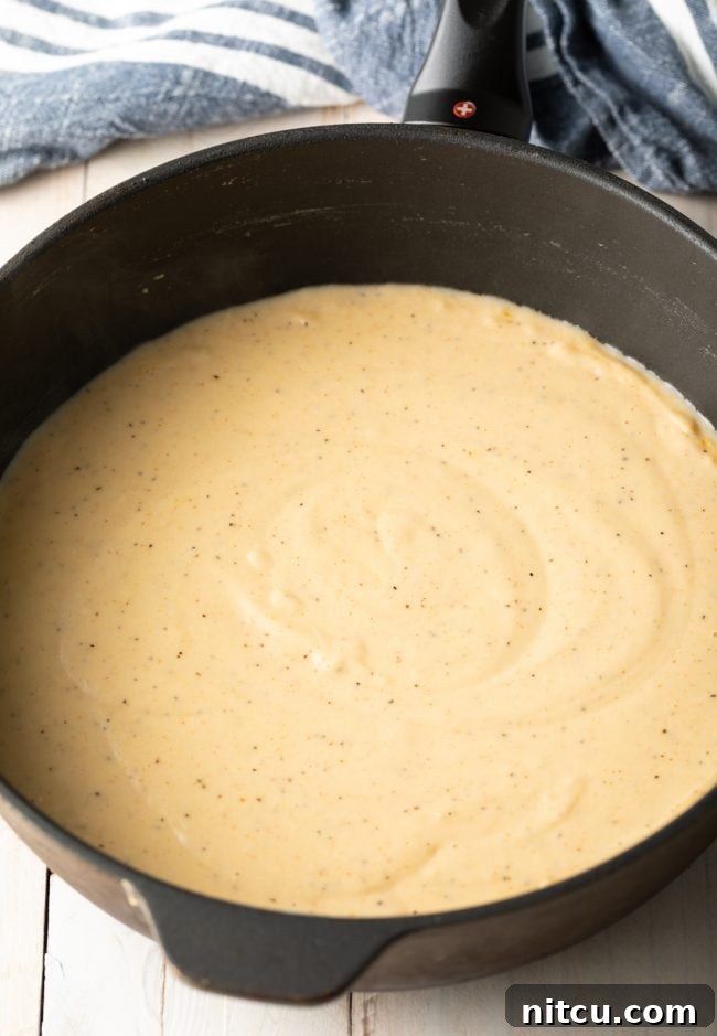 Effortless Chicken Fried Steak 8 Country Gravy Recipe: A close-up of a rich, creamy white country gravy, showing its smooth texture and hints of black pepper.