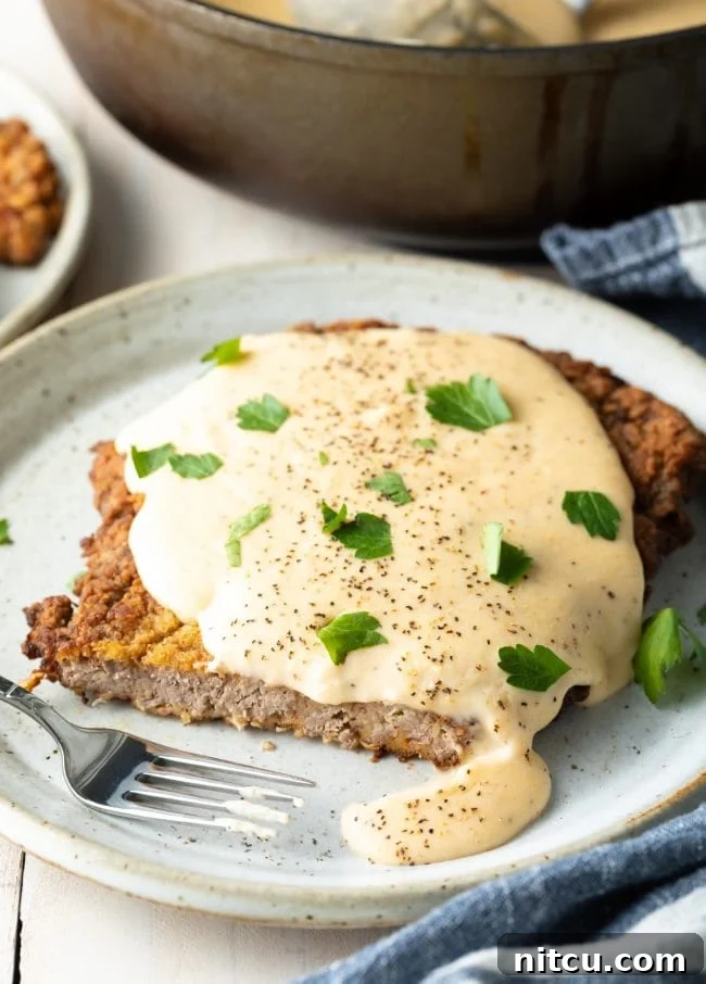 Effortless Chicken Fried Steak 10 How to make chicken fried steak: A final, mouth-watering shot of a chicken fried steak dinner, complete with sides, emphasizing the comfort and satisfaction of the meal.