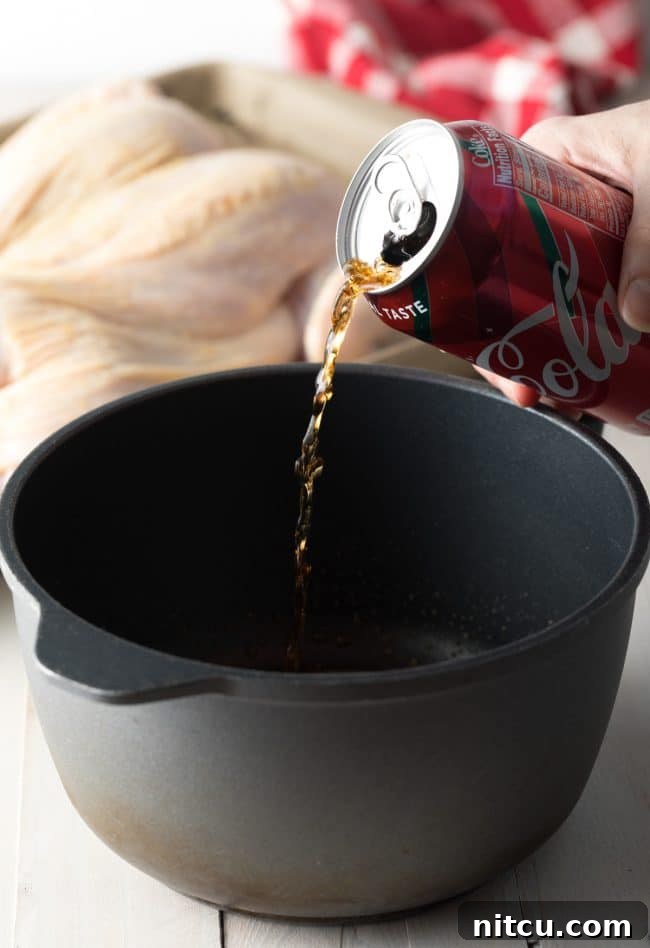 Coca Cola Glazed Spatchcock Chicken 4 Pouring Coca-Cola into a pan to prepare the glaze.