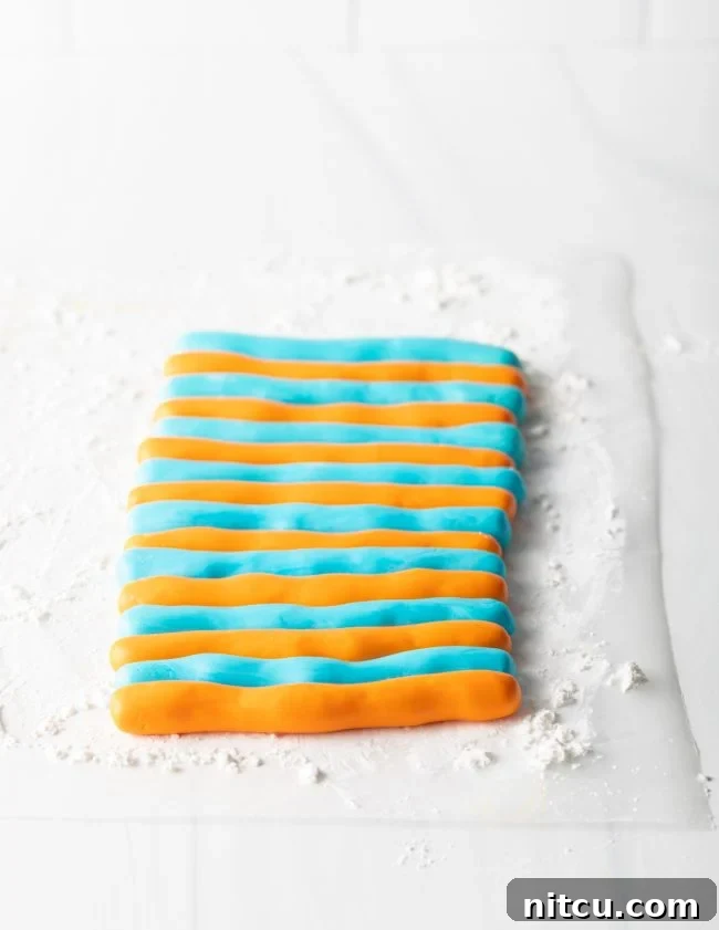 Easy Homemade Fondant 9 Orange and blue striped fondant being prepped to be rolled out.