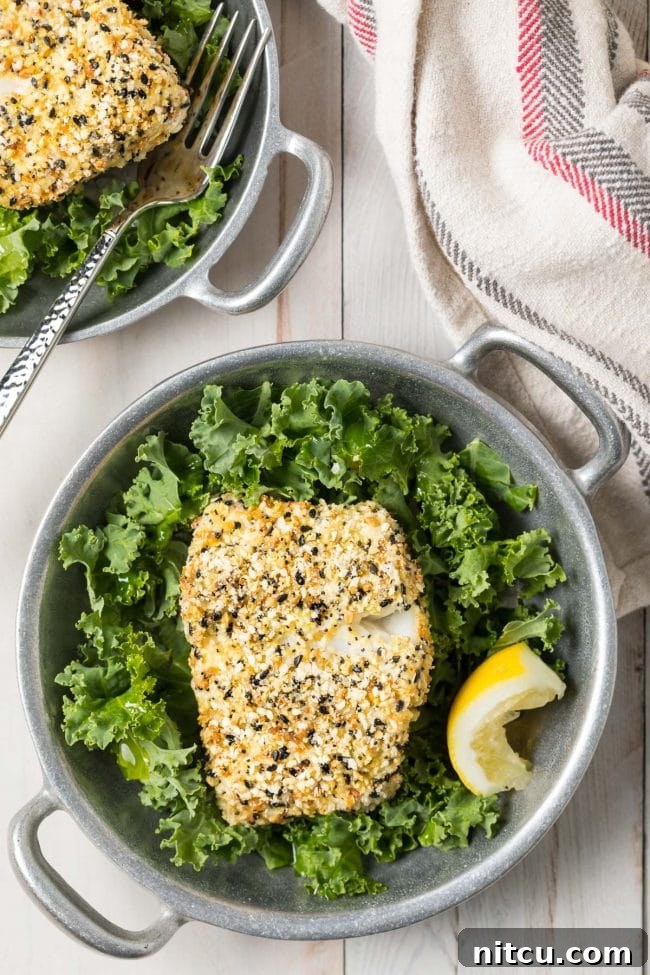 Everything Bagel Crusted Cod 3 Crispy everything bagel seasoned cod served in a bowl with lettuce and lemon.