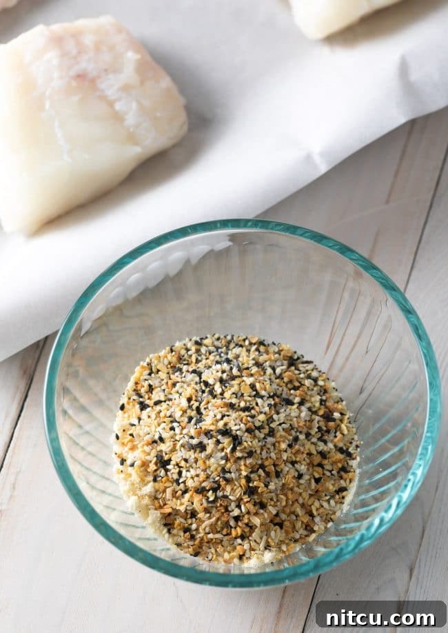 Everything Bagel Crusted Cod 5 Raw white fish next to a small bowl of everything bagel seasoning.