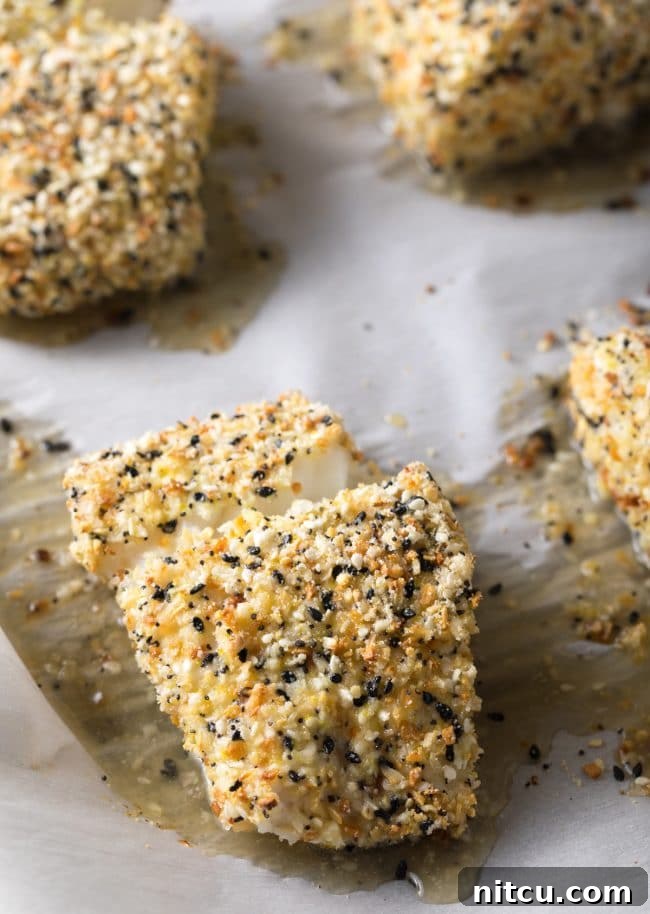 Everything Bagel Crusted Cod 9 Everything bagel seasoned cod on a baking sheet after being baked.